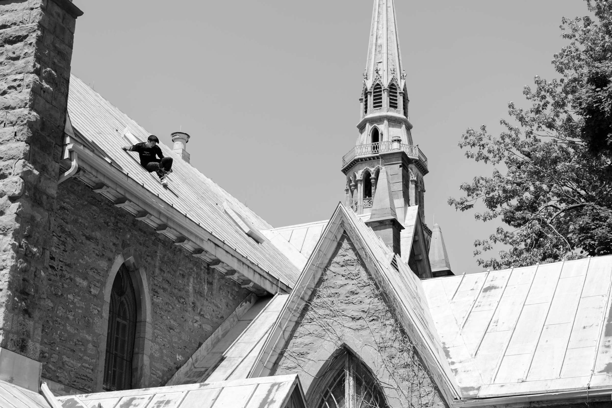 Dylan Cheung sliding down the roof of a church in prep for a jump over a gap